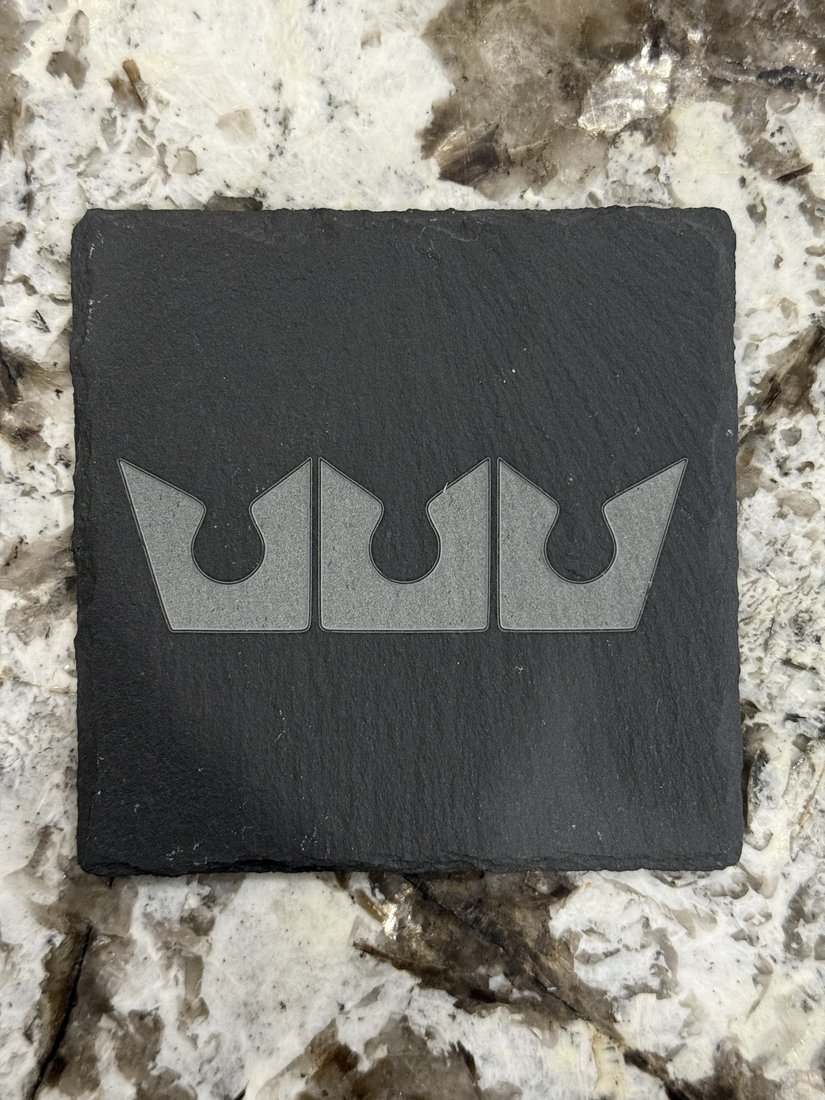Engraved slate coaster with a crown emblem